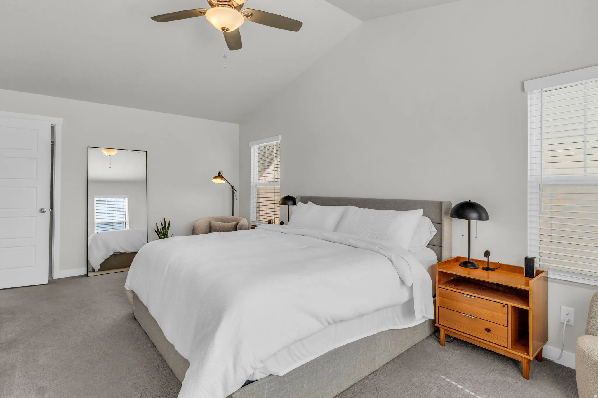 Bedroom with lofted ceiling, a ceiling fan, and carpet flooring