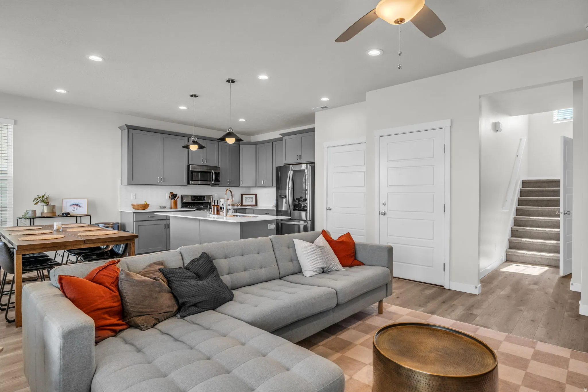 Living room with light wood-type flooring, ceiling fan, and recessed lighting
