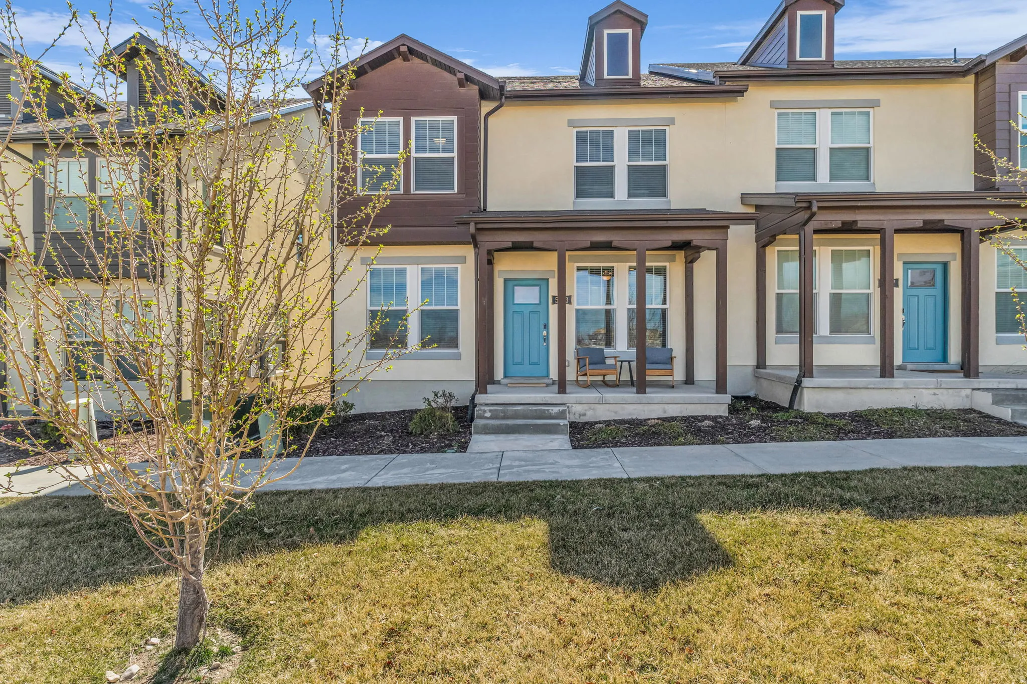 View of front of home with stucco siding, a front yard, and a porch