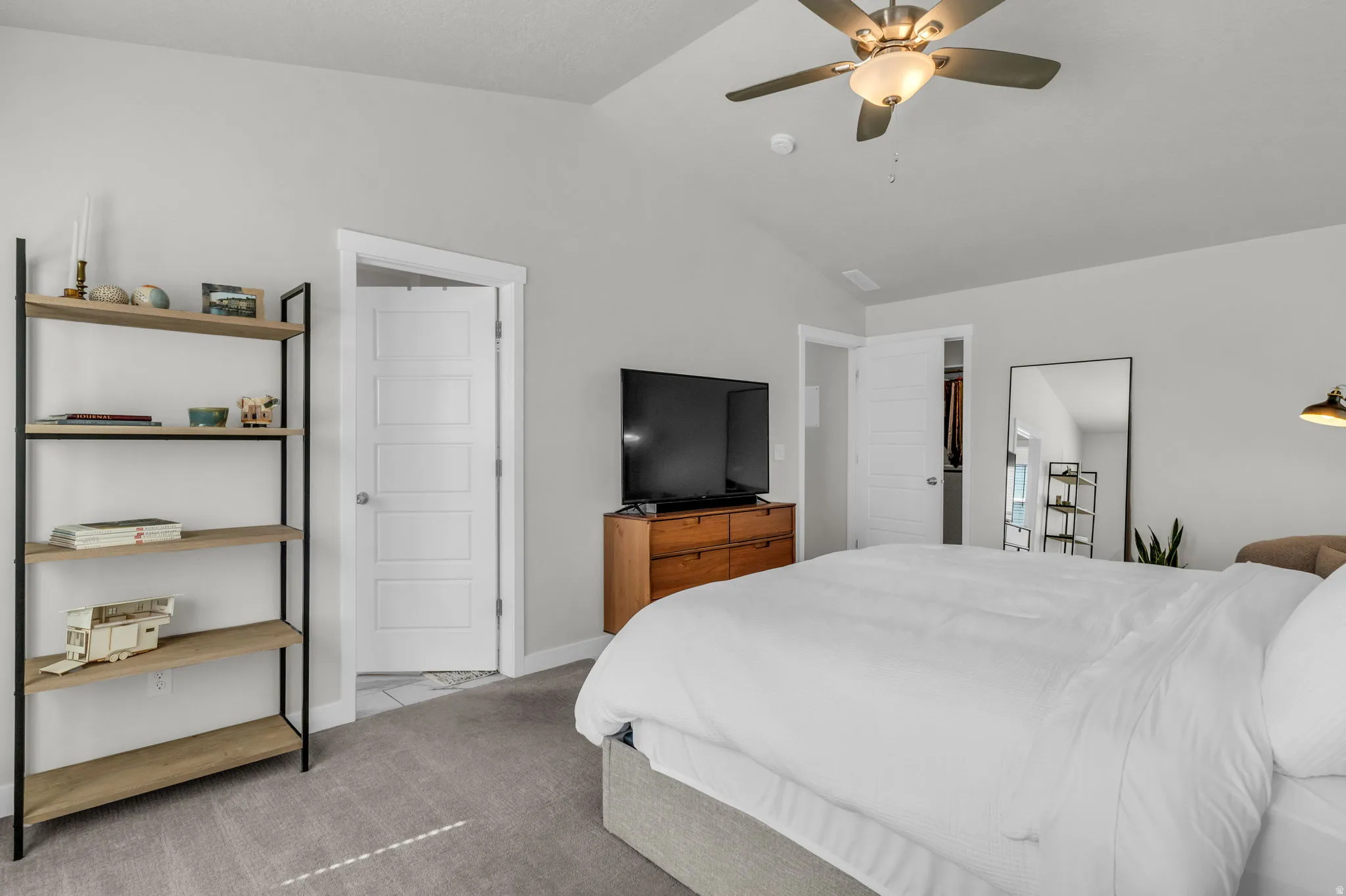 Carpeted bedroom featuring a ceiling fan and baseboards