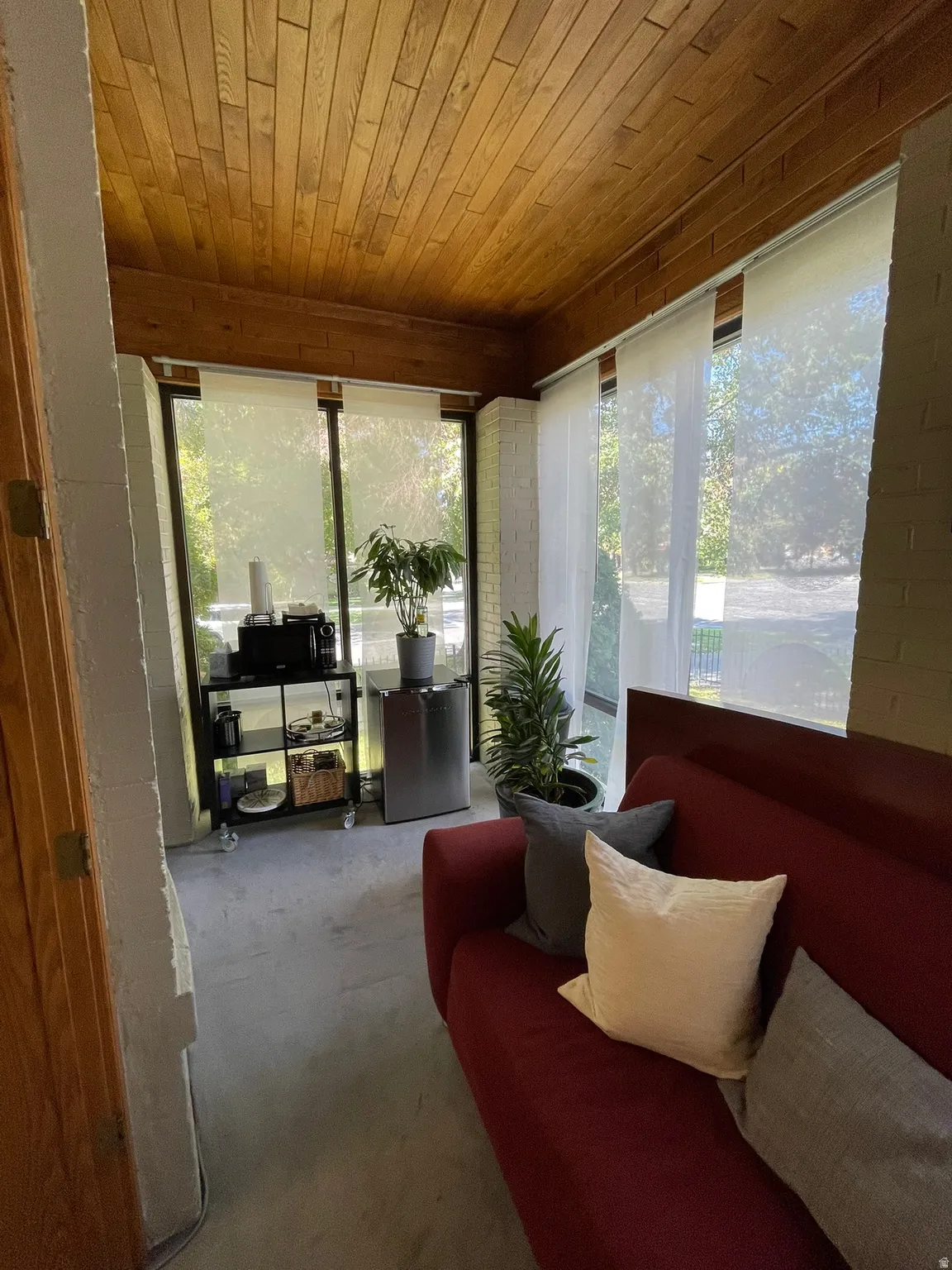 Sunroom / solarium with carpet flooring, wooden ceiling, and plenty of natural light