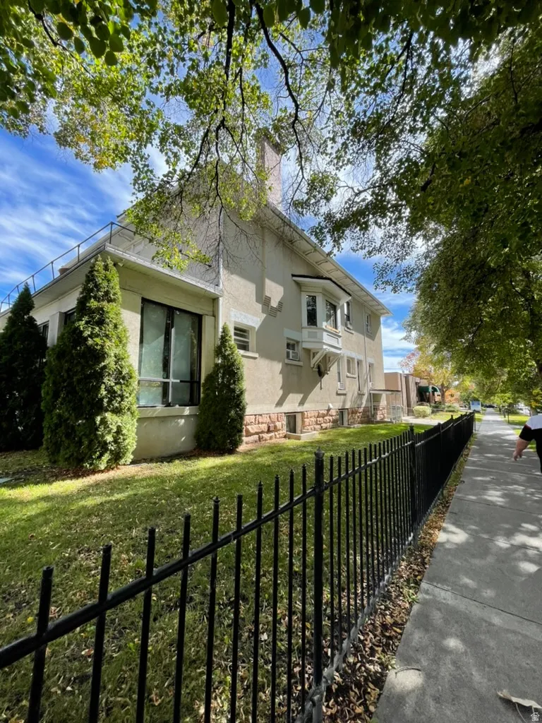 View of front facade with a chimney and stucco siding