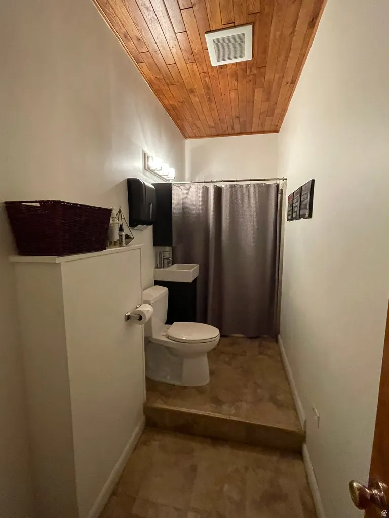 Bathroom with wood ceiling and curtained shower