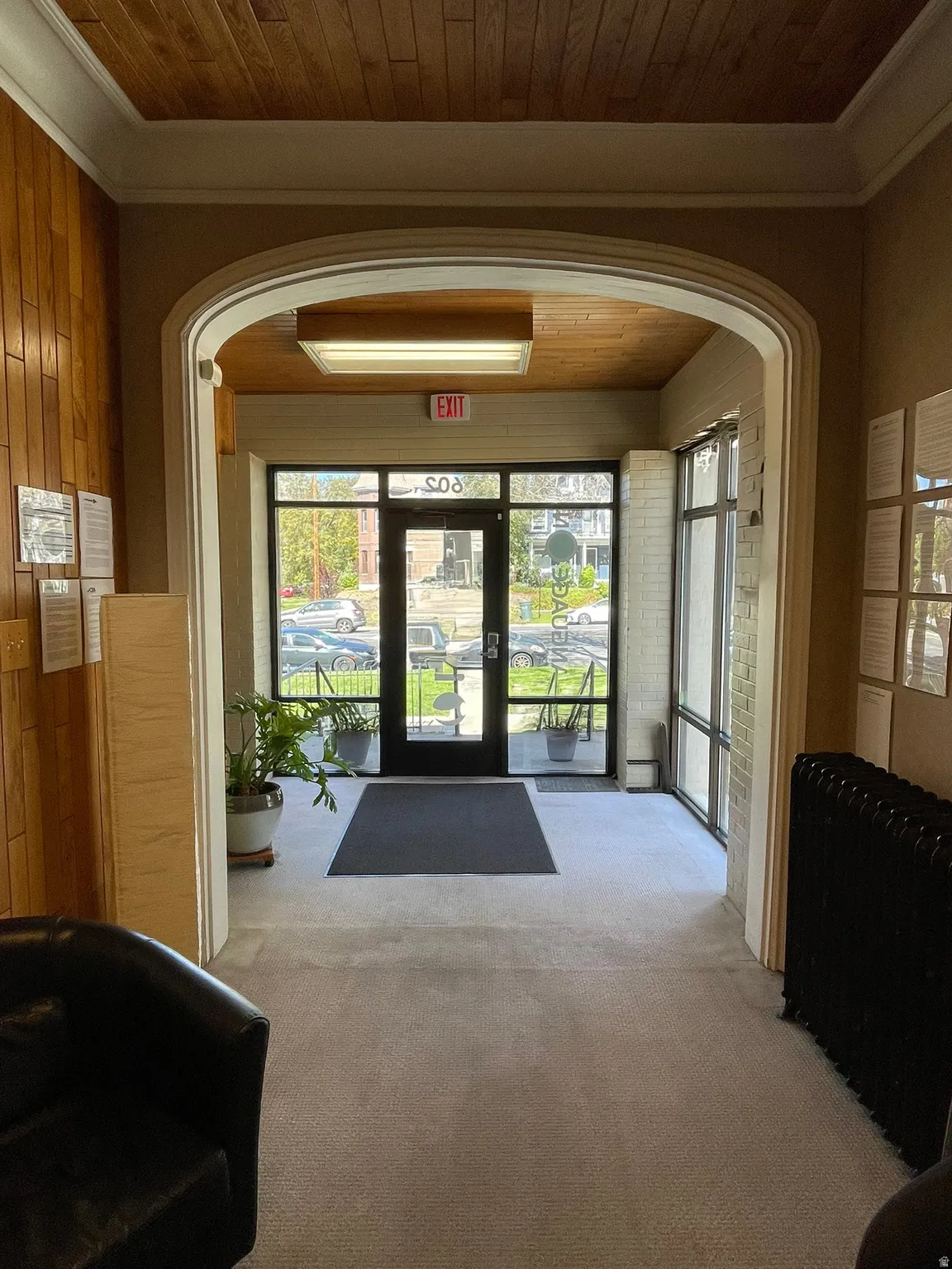 Lobby featuring crown molding, wood ceiling, and wooden walls