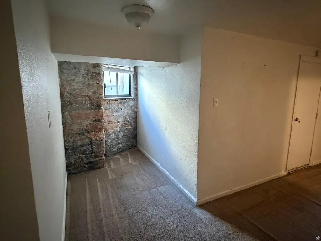 Exposed stone wall with a window and white blinds