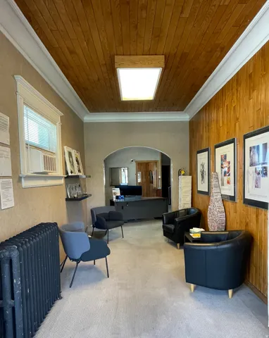 Lobby with wood walls, crown molding, and wood ceiling