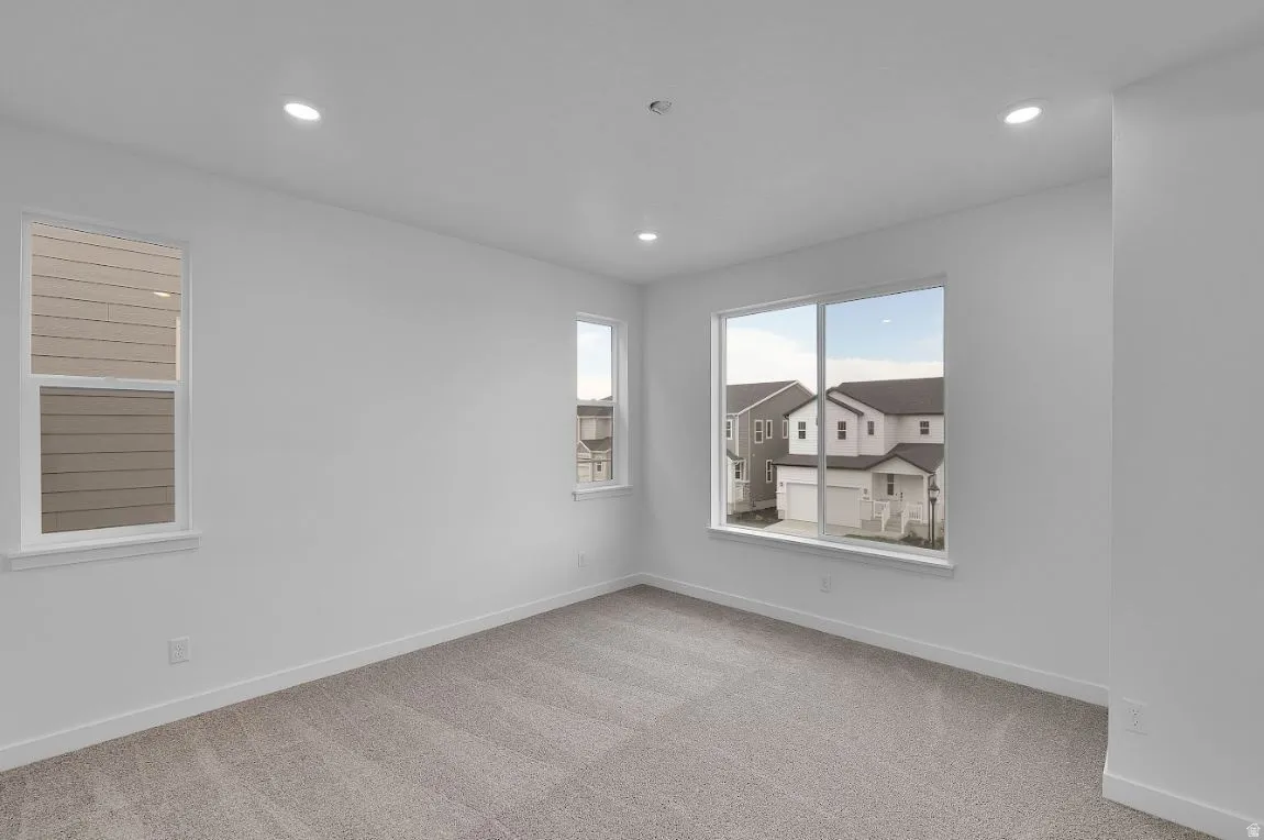 Unfurnished room with light colored carpet and recessed lighting