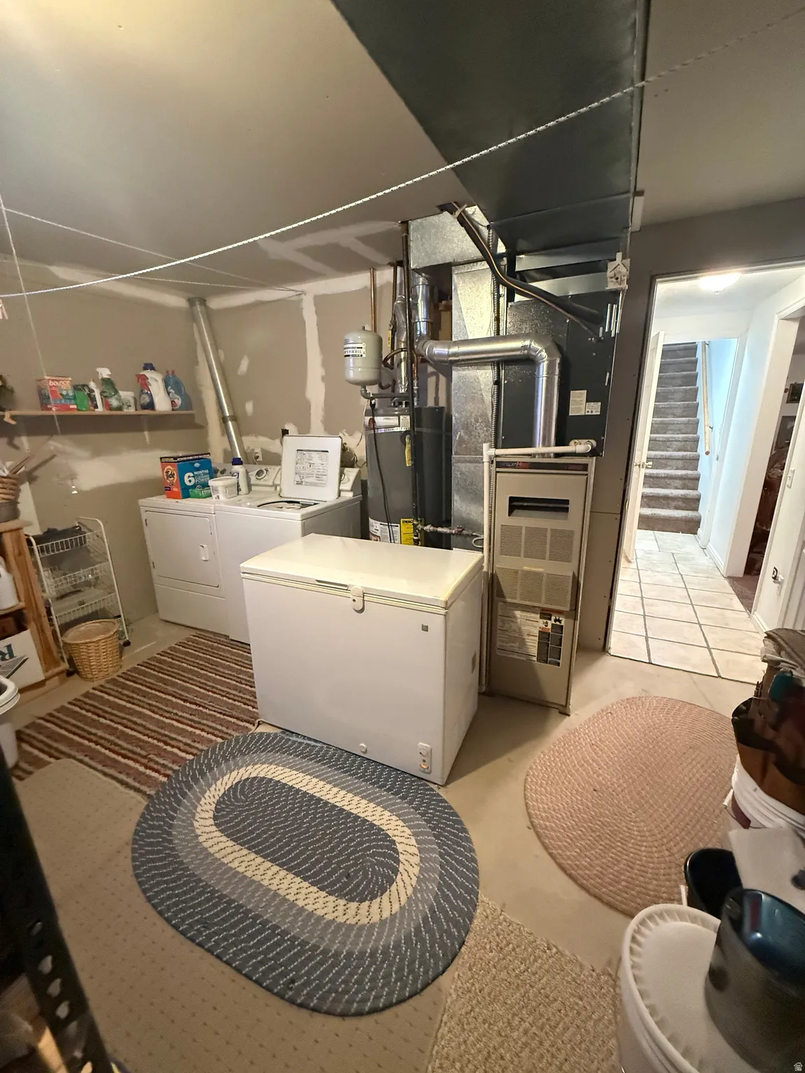 Below grade area with separate washer and dryer, gas water heater, and heating unit