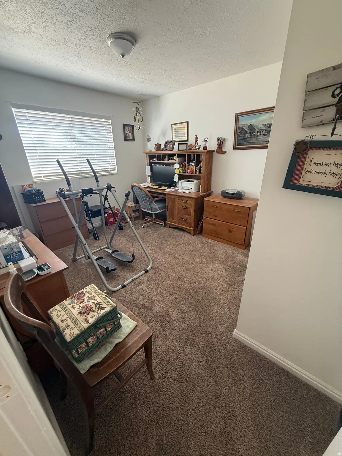 Office featuring dark colored carpet and a textured ceiling