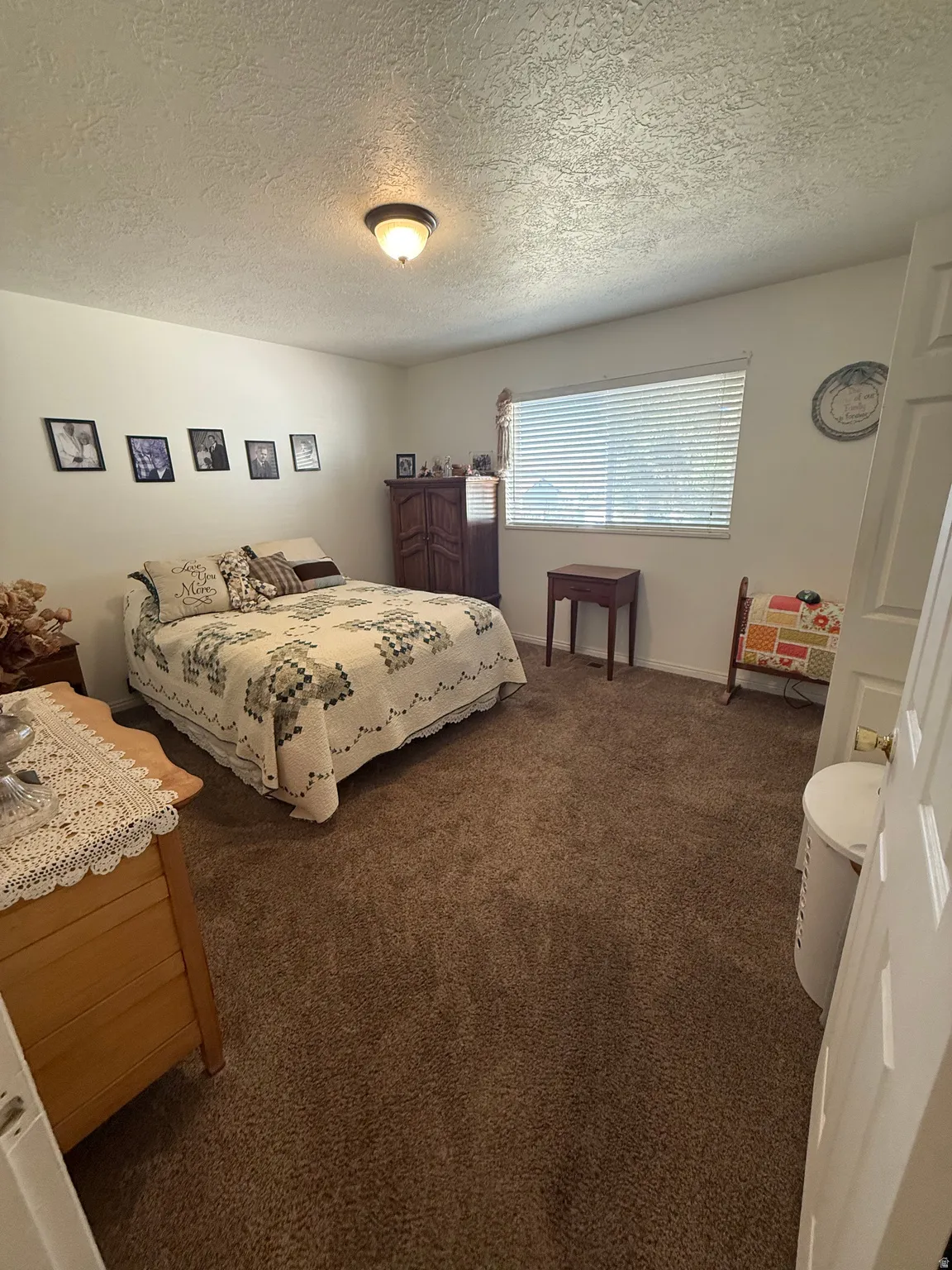 Bedroom featuring dark colored carpet and a textured ceiling