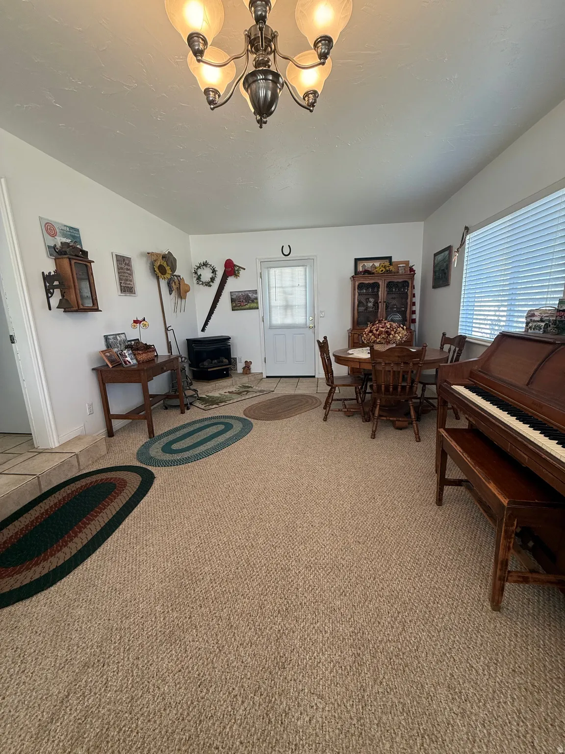 Living area with light colored carpet and a chandelier