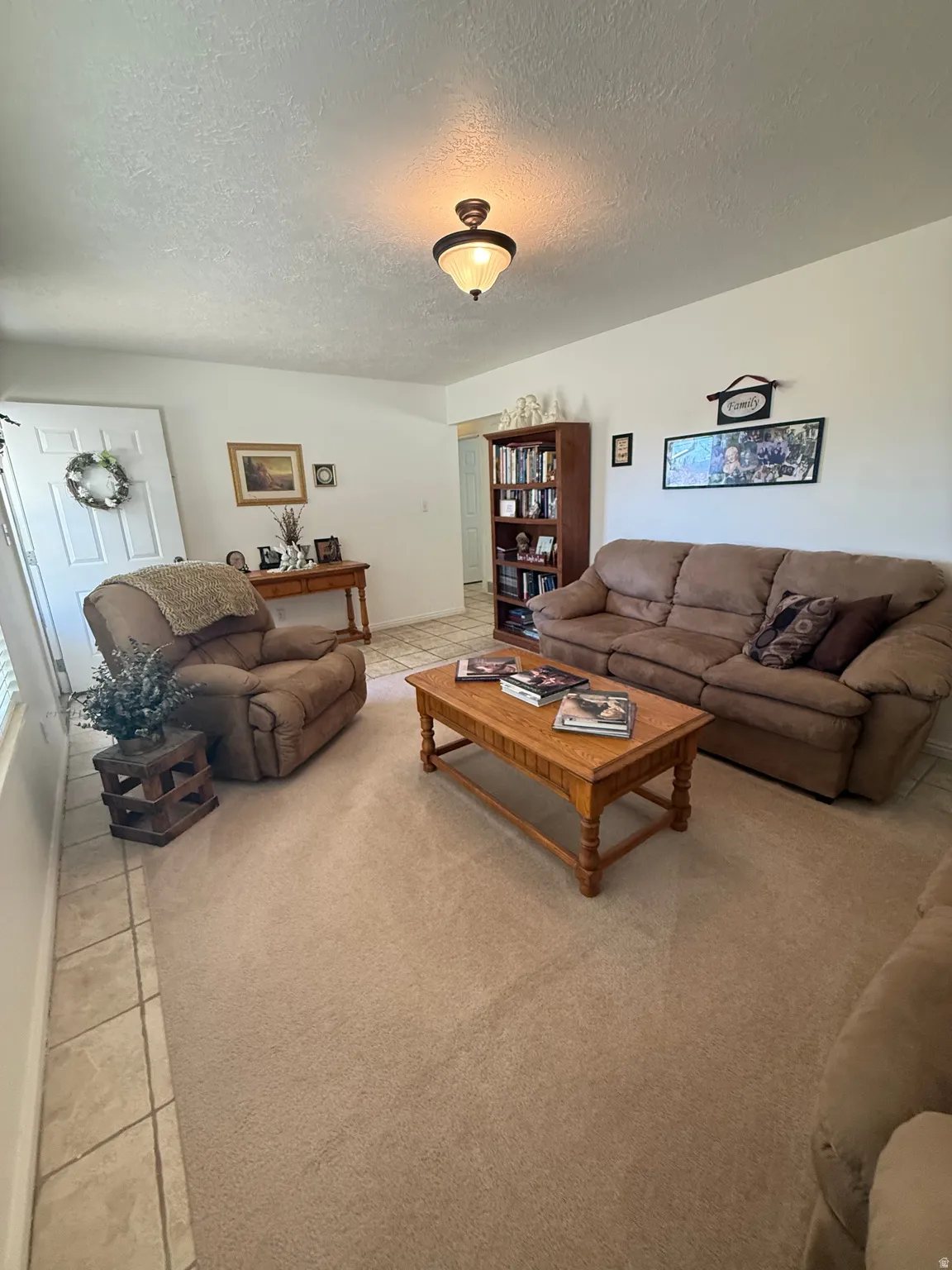 Living area featuring a textured ceiling and light tile patterned floors