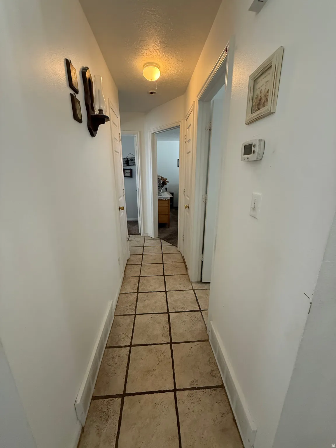 Hall with baseboards and a textured ceiling