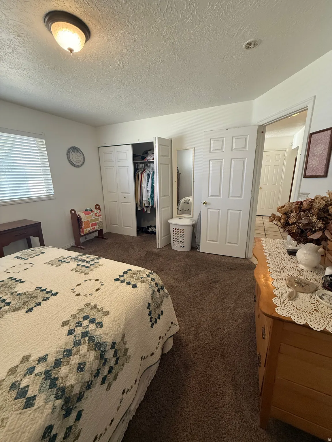 Bedroom featuring dark carpet, a closet, and a textured ceiling