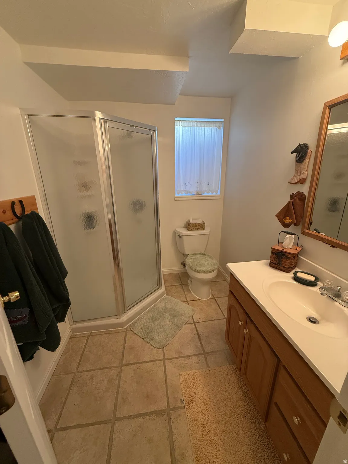 Full bathroom featuring a stall shower, vanity, and light tile patterned floors