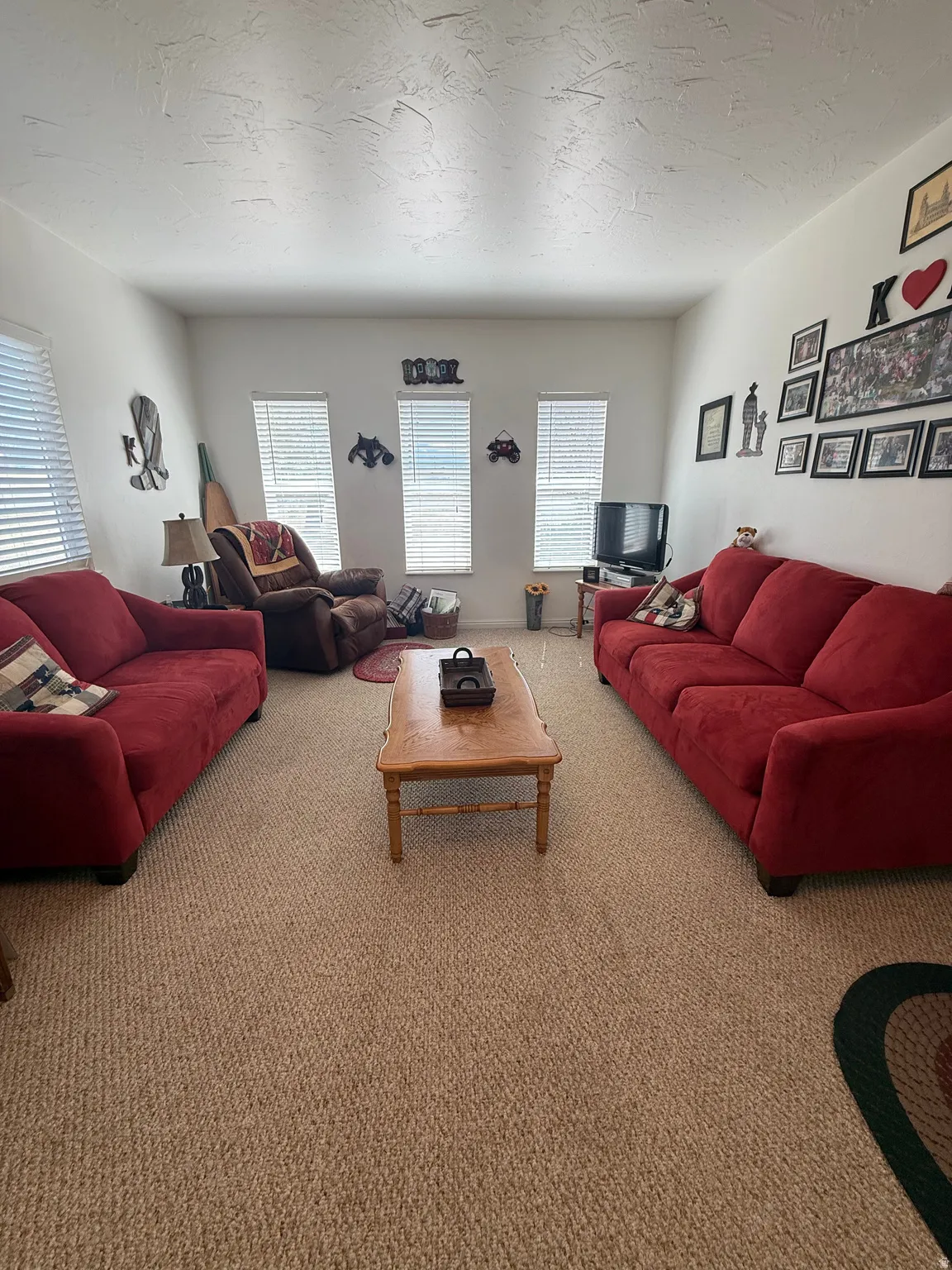 Living area with carpet flooring and a textured ceiling