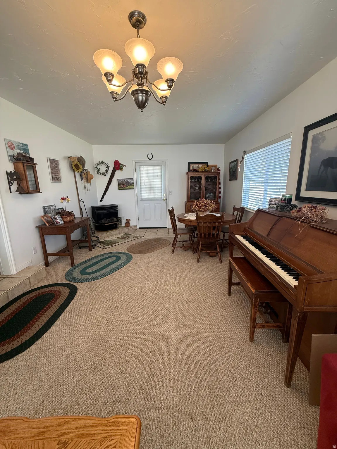 Sitting room with hanging lights and light colored carpet