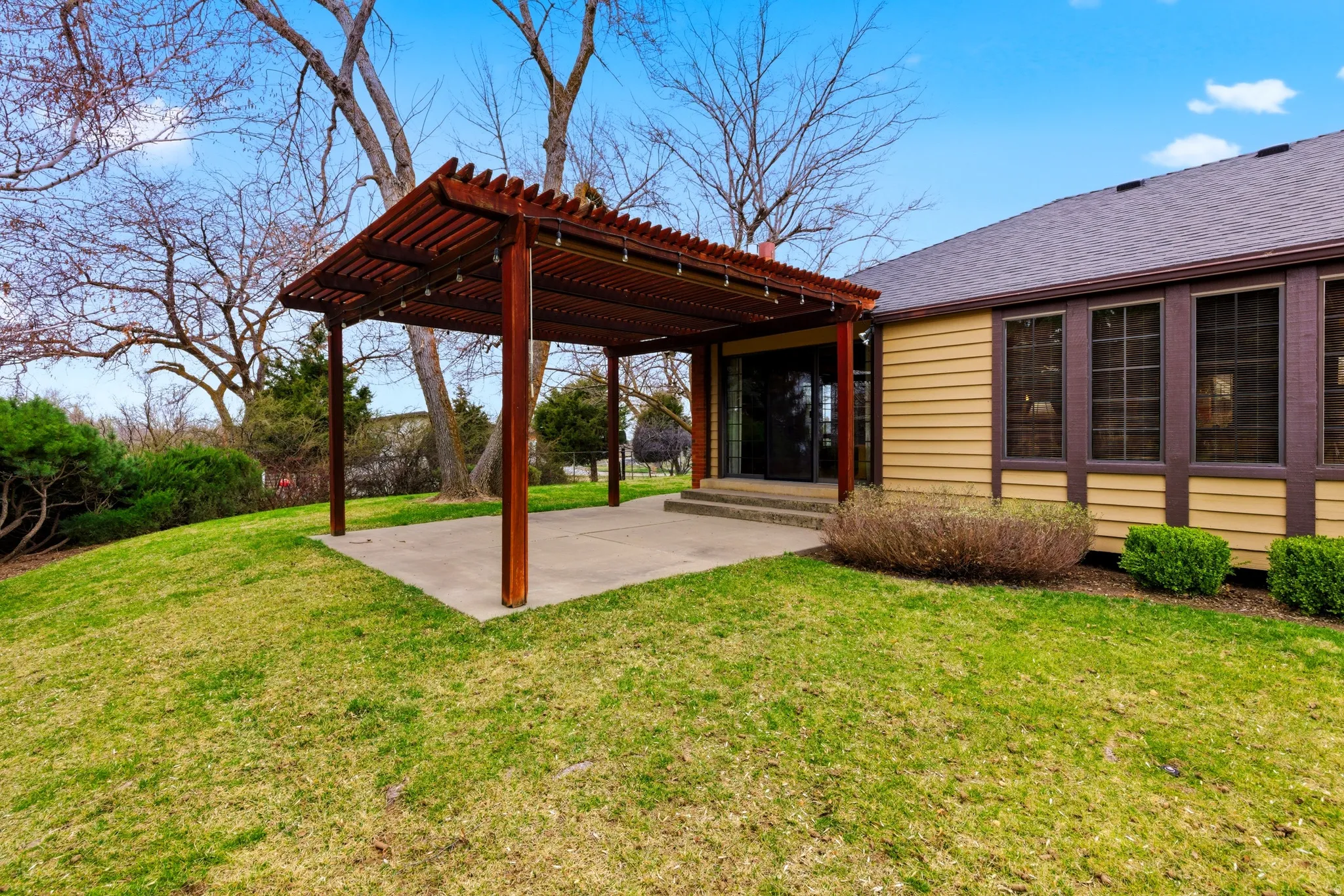 Back of house with a lawn, a patio area, and a pergola