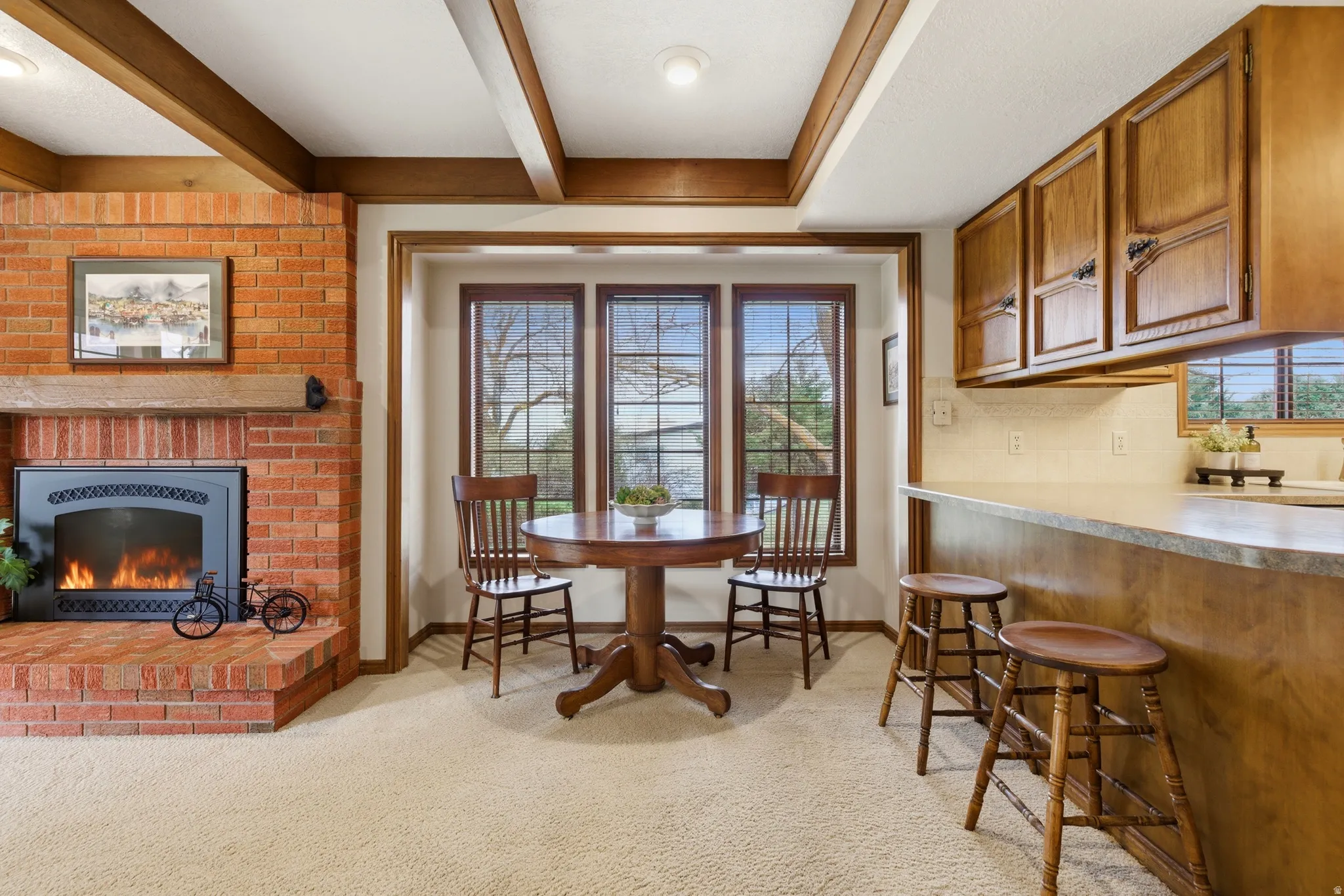 Dining area featuring light carpet and a fireplace