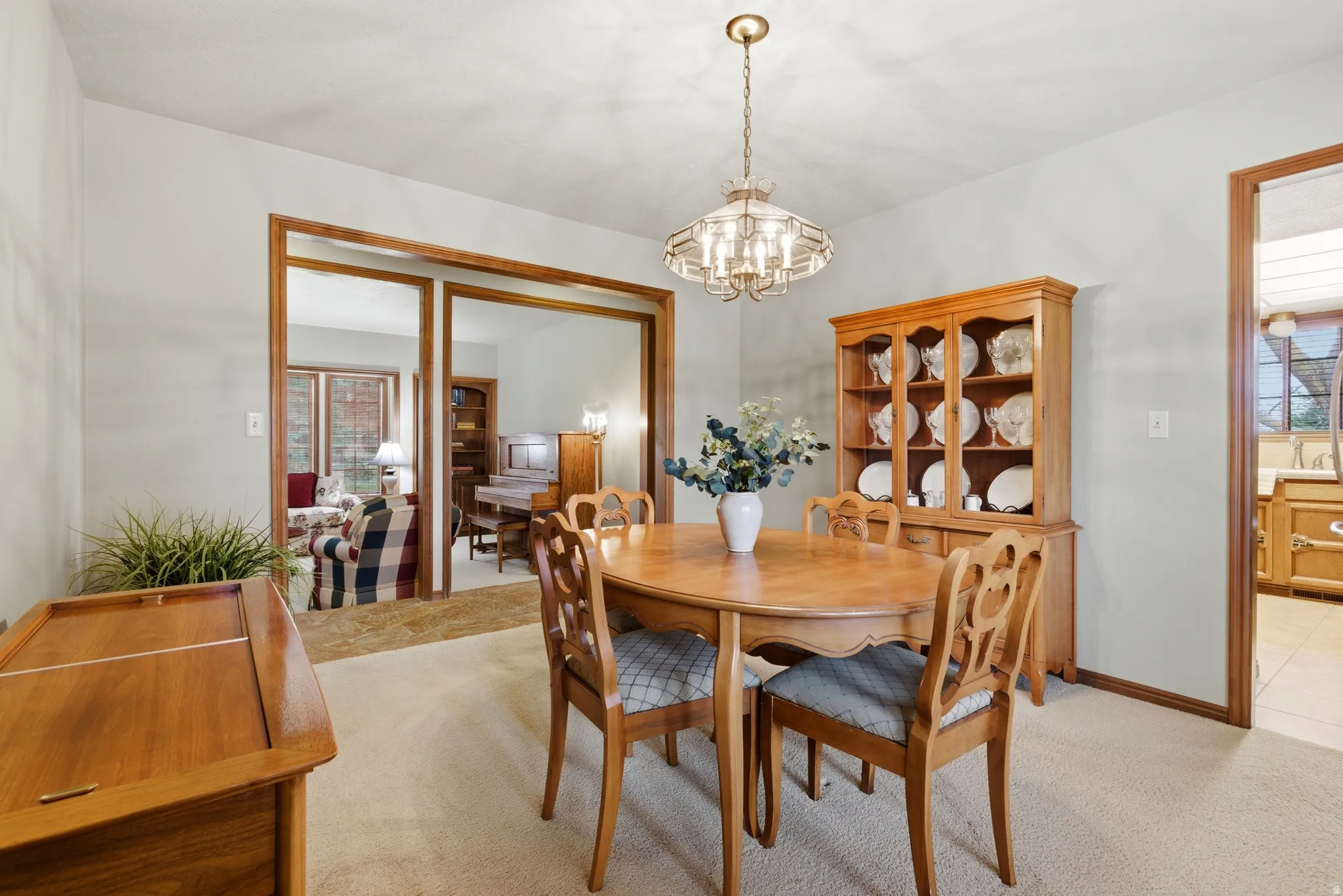 Dining room with light colored carpet and suspended lighting