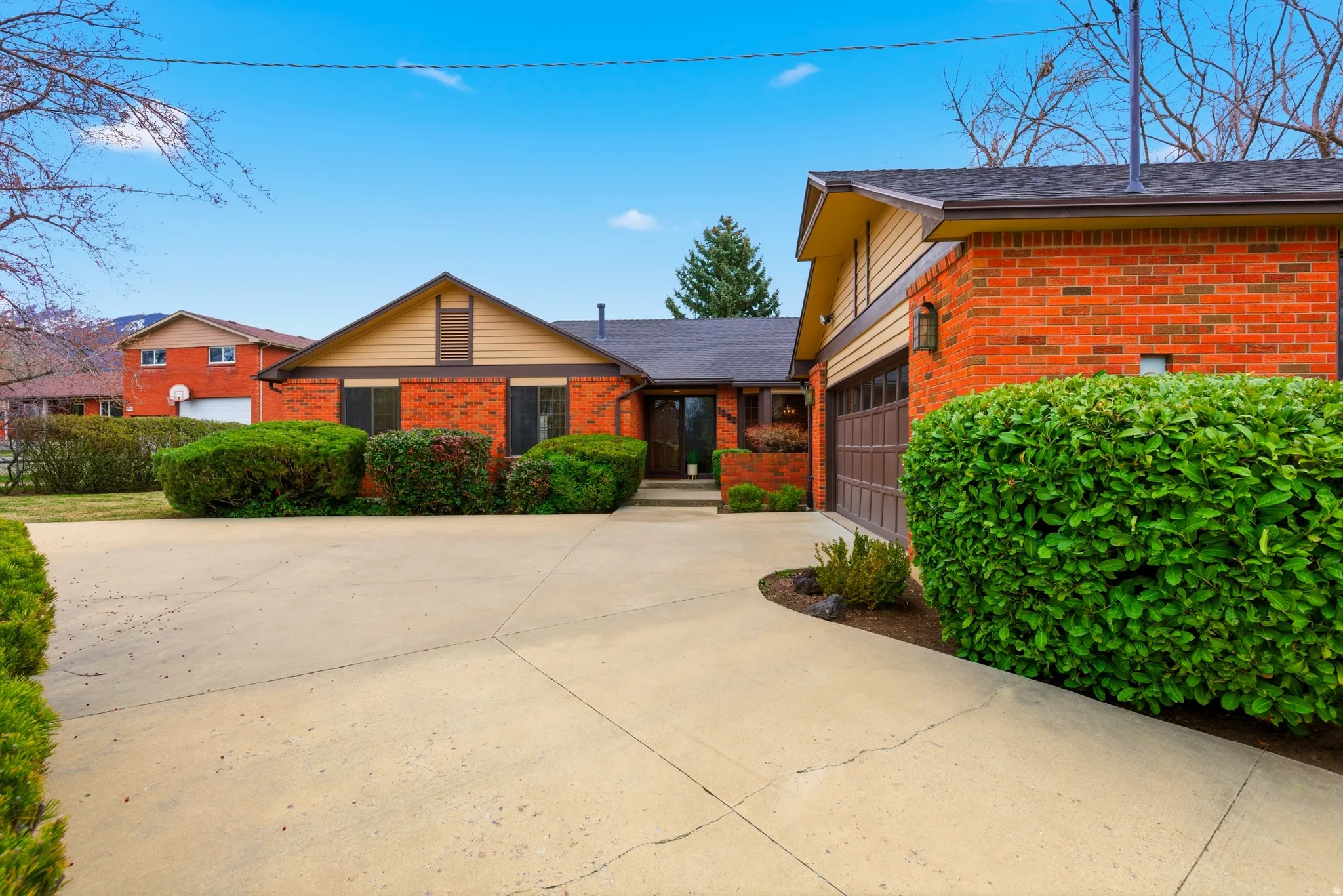 View of front of house featuring brick siding, concrete driveway, and a garage