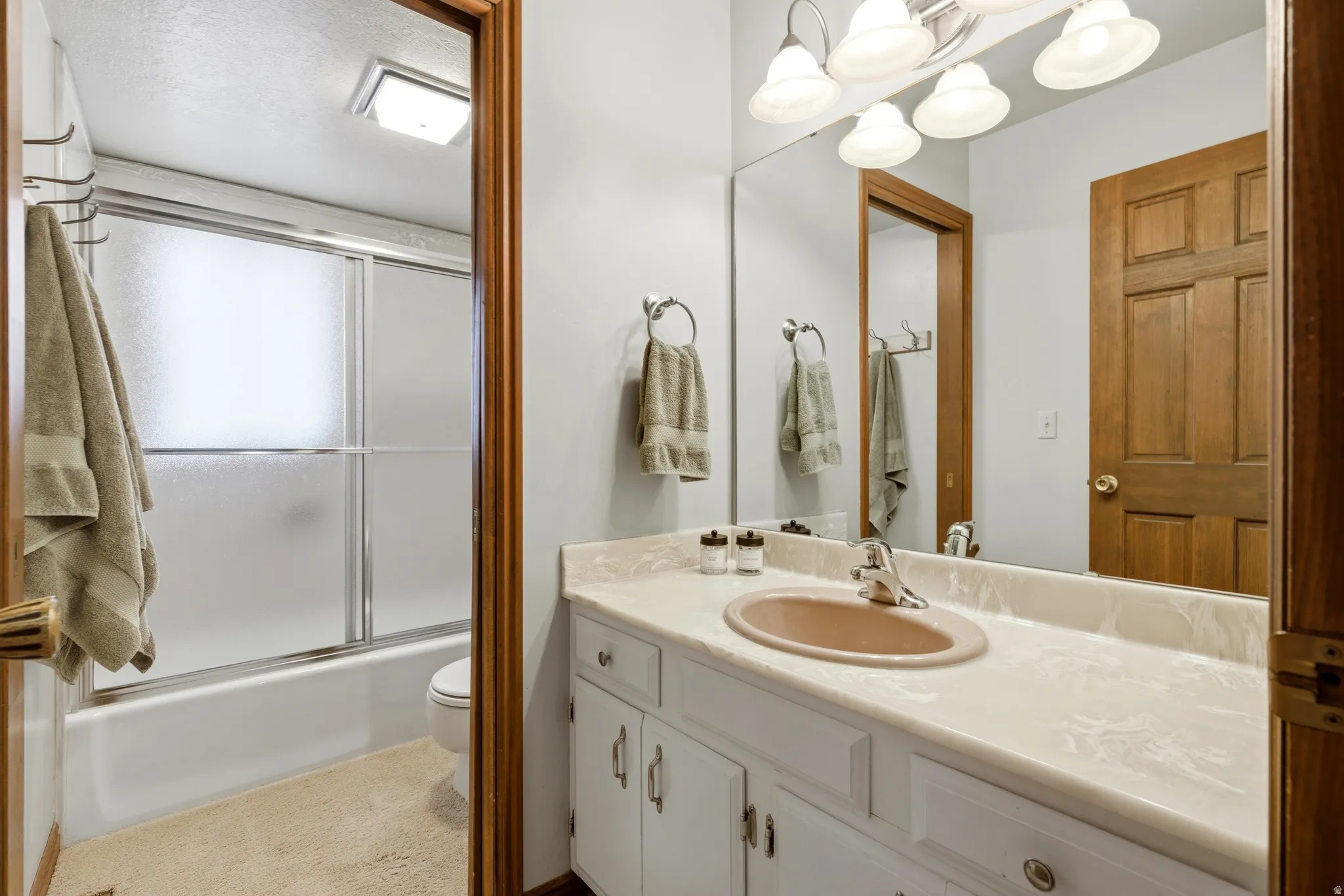 Full bath with vanity and combined bath / shower with glass door