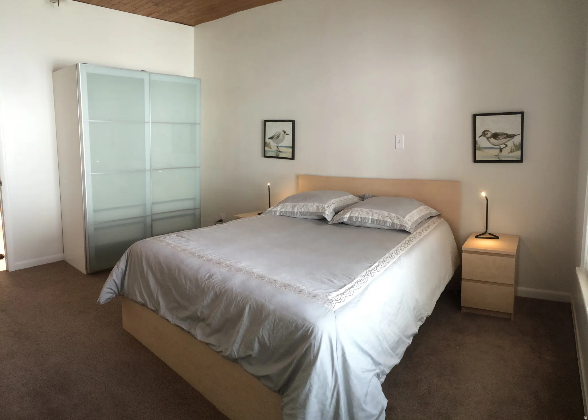 Bedroom with dark carpet and wooden ceiling