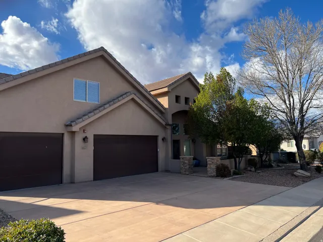 View of front of house with driveway, stucco siding, an attached garage, and a tiled roof