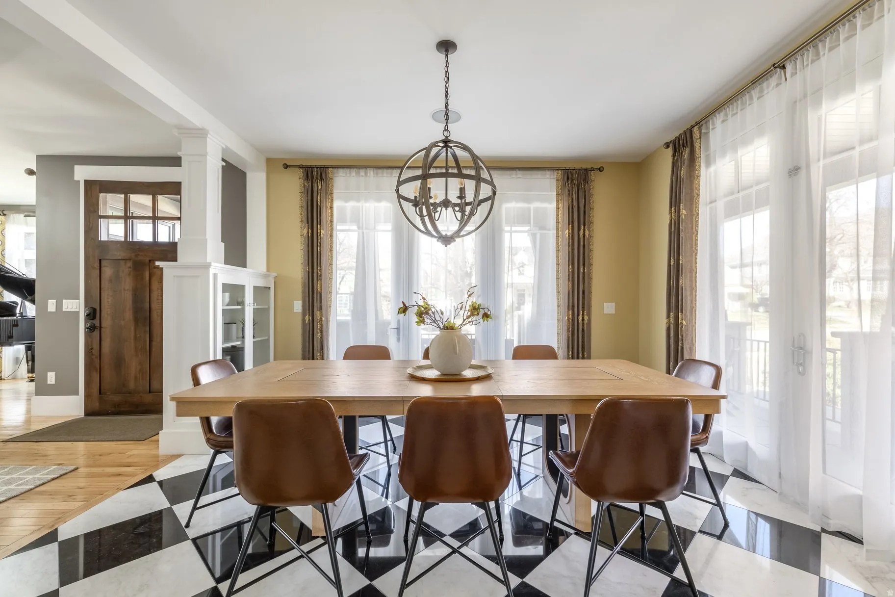 Dining room featuring decorative columns, hanging lights, and light wood-style flooring