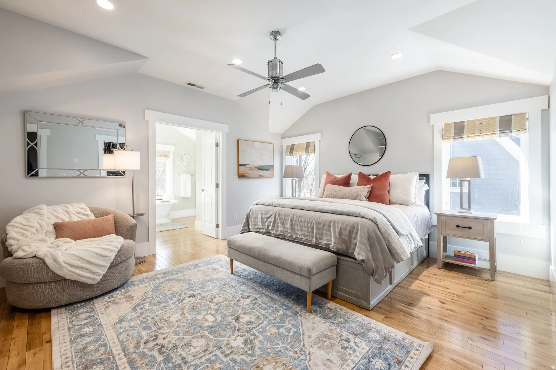 Bedroom with recessed lighting, light wood-style flooring, ensuite bath, vaulted ceiling, and a ceiling fan