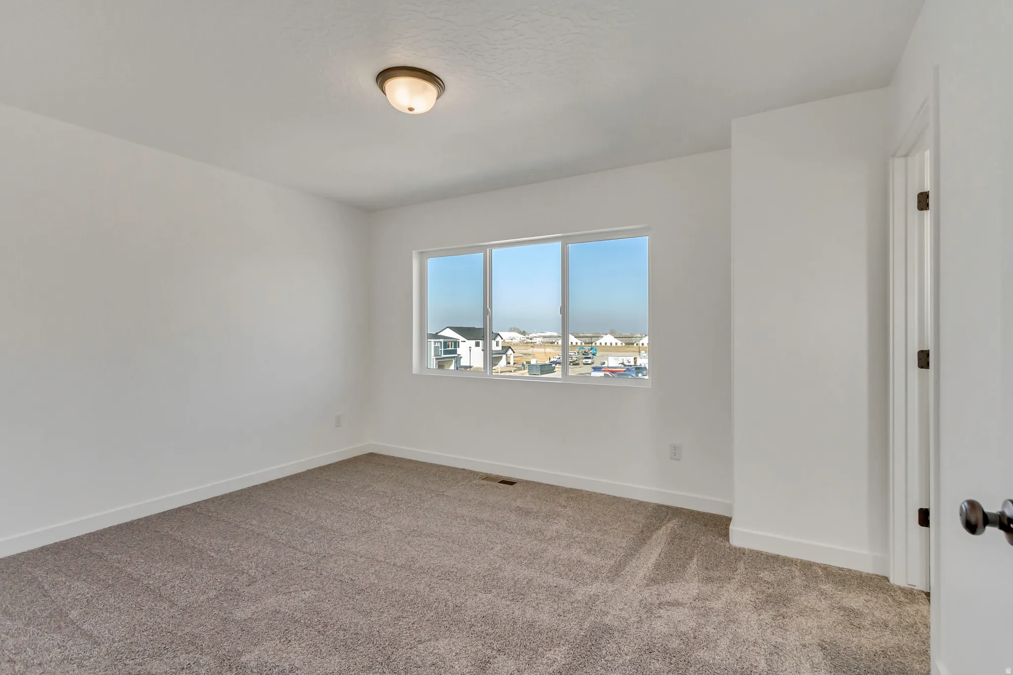 Unfurnished room with light colored carpet and baseboards