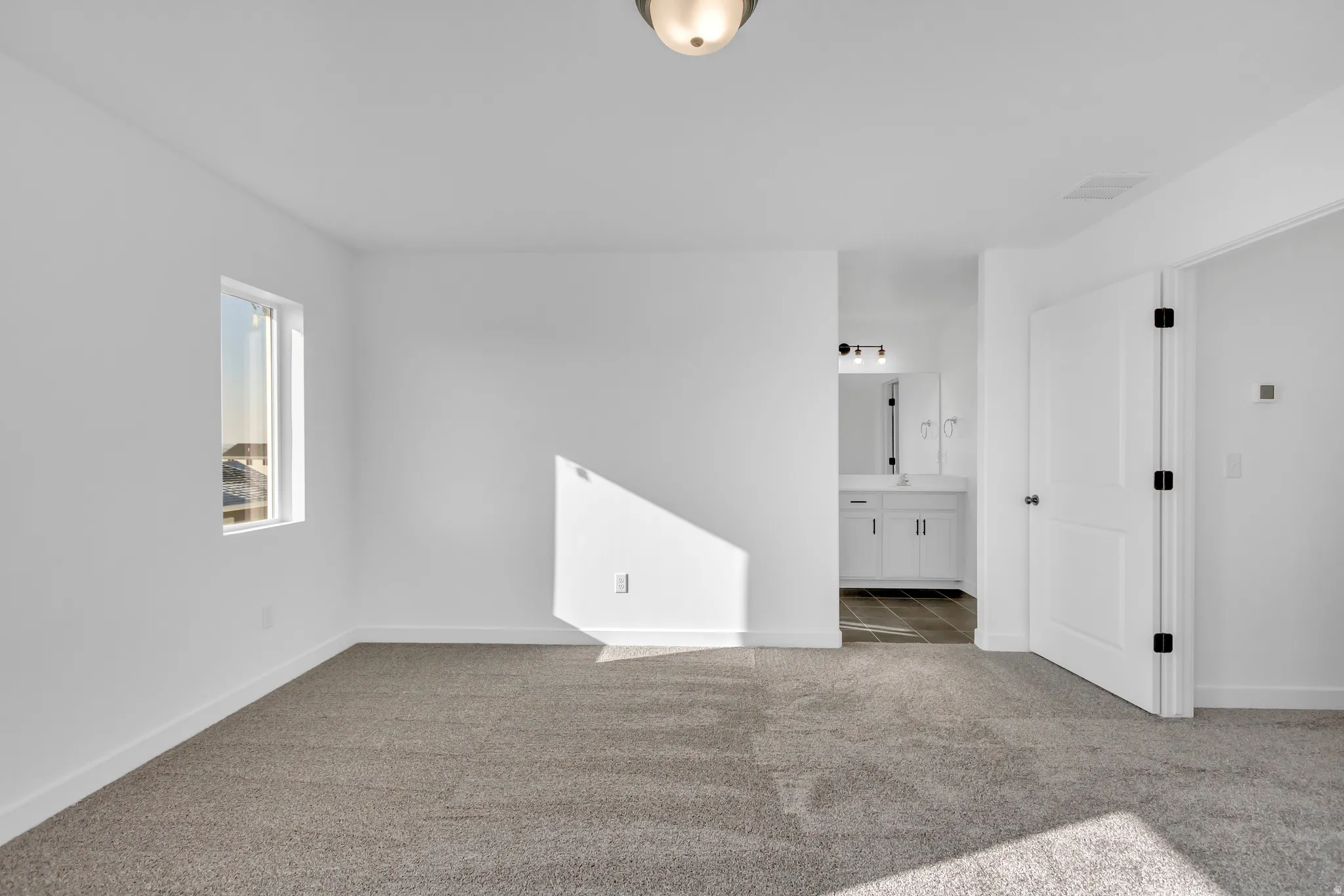Carpeted empty room featuring baseboards