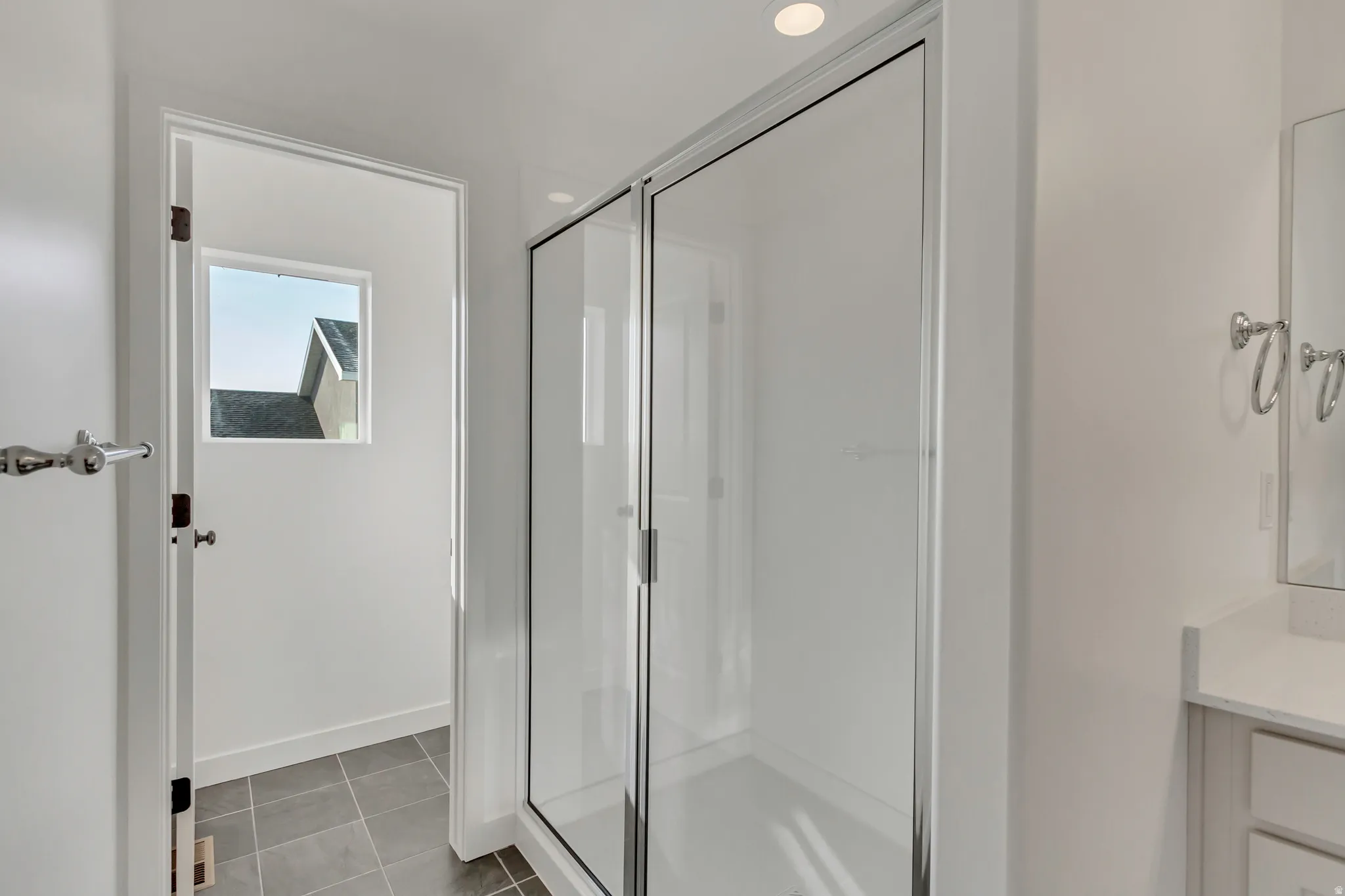 Bathroom with vanity, a stall shower, and light tile patterned floors