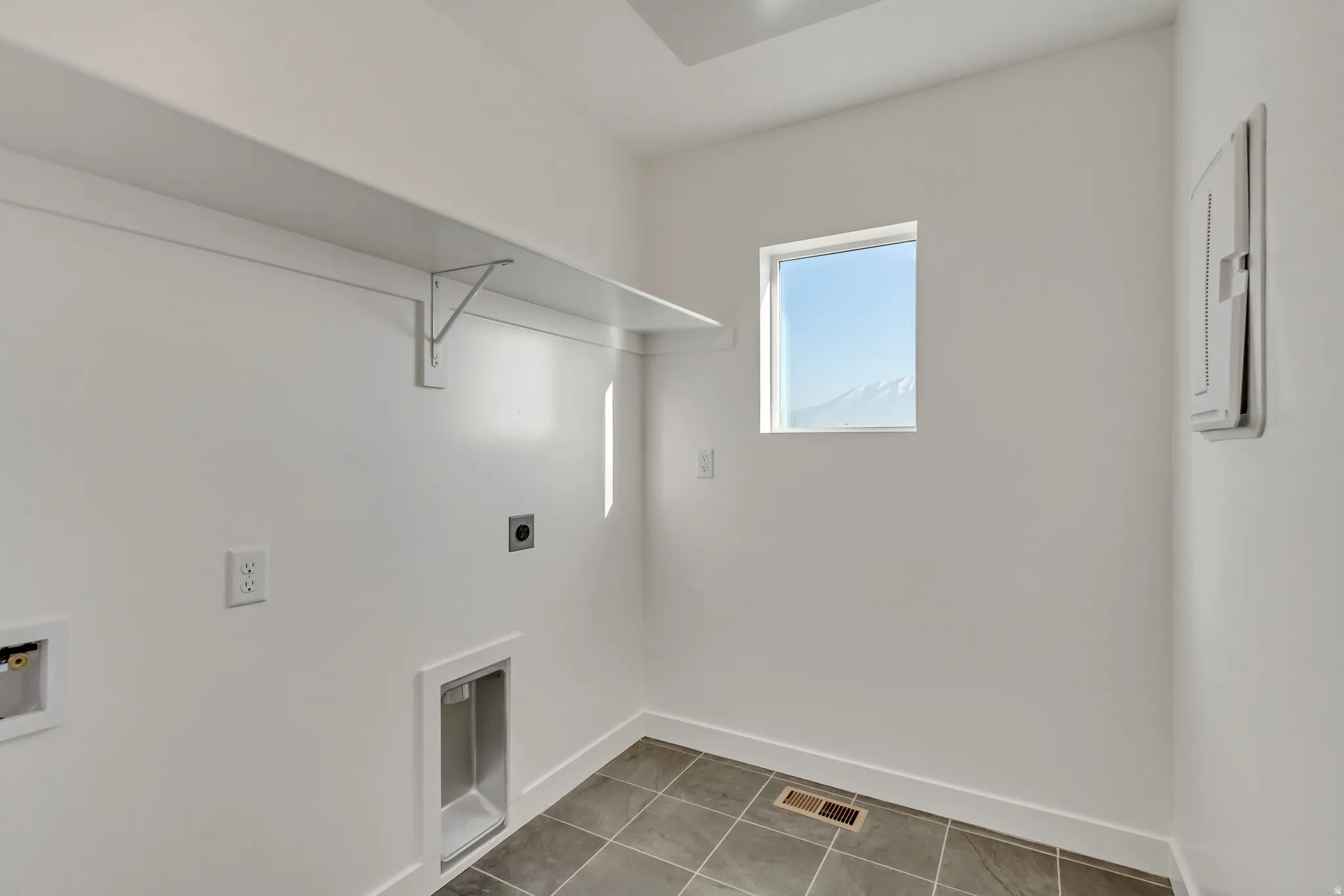 Laundry area featuring hookup for an electric dryer, tile patterned floors, washer hookup, and electric panel