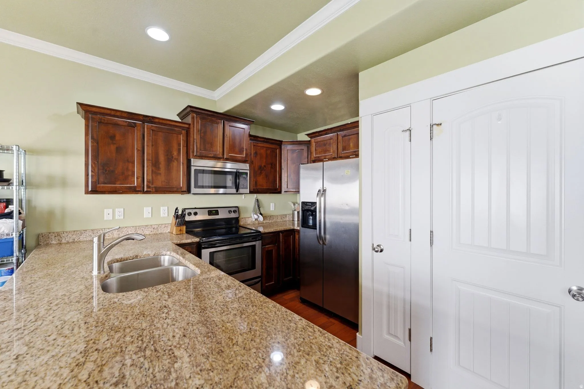 Kitchen with dark wood cabinetry and light granite counters