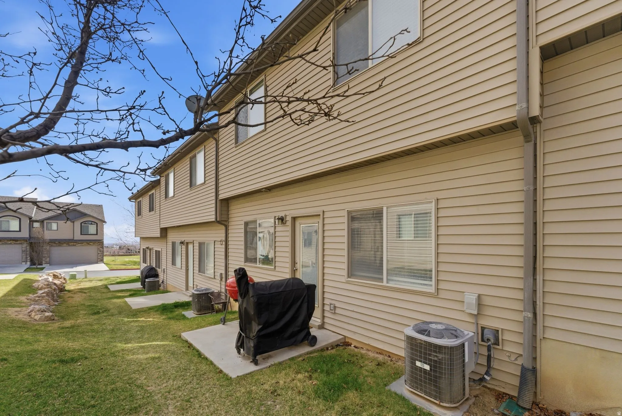 Rear view of property with patio and green space