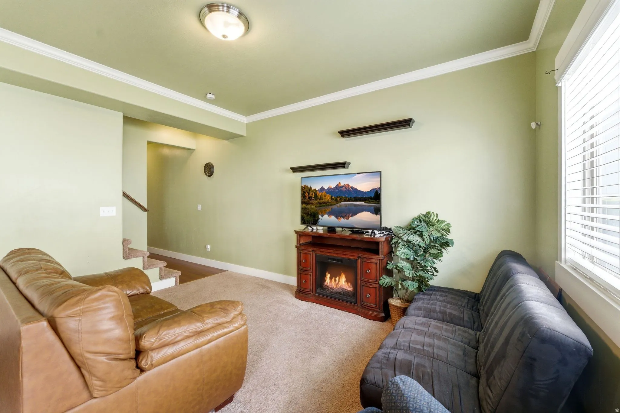 Living room facing staircase to second level and foyer.