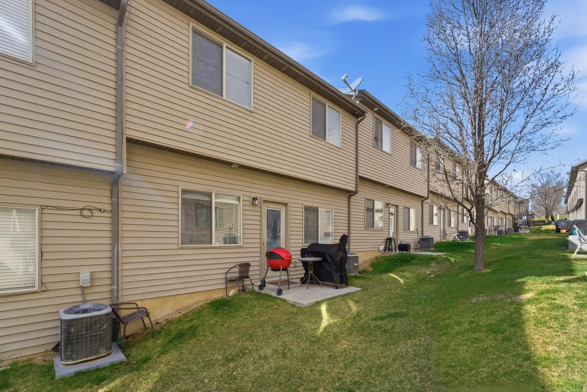 Rear view of property with patio and green space.