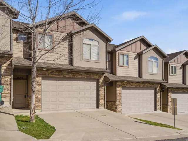 Craftsman inspired home featuring an attached garage, stone siding and concrete driveway.
