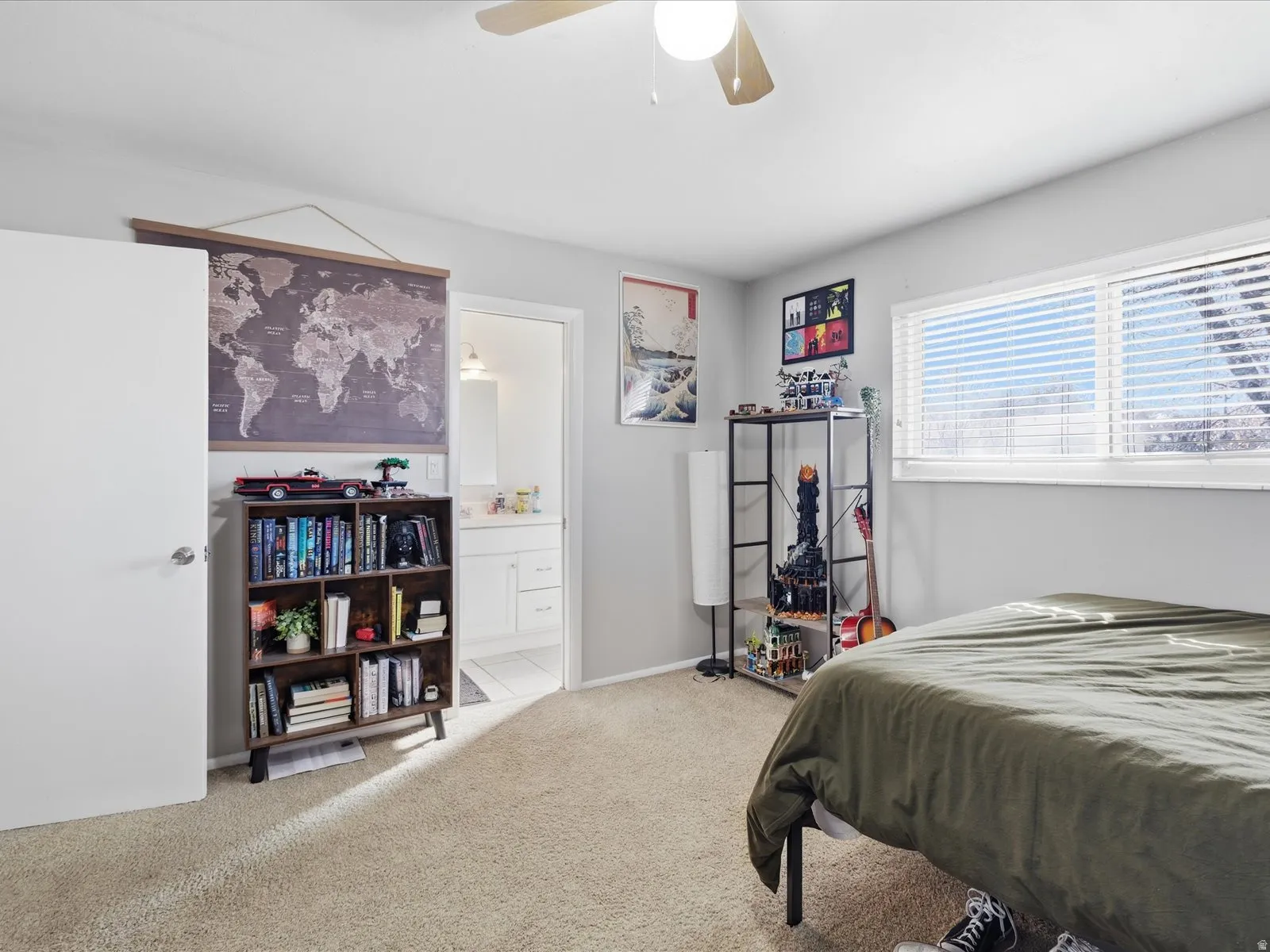 Bedroom with light colored carpet, ensuite bathroom, and ceiling fan