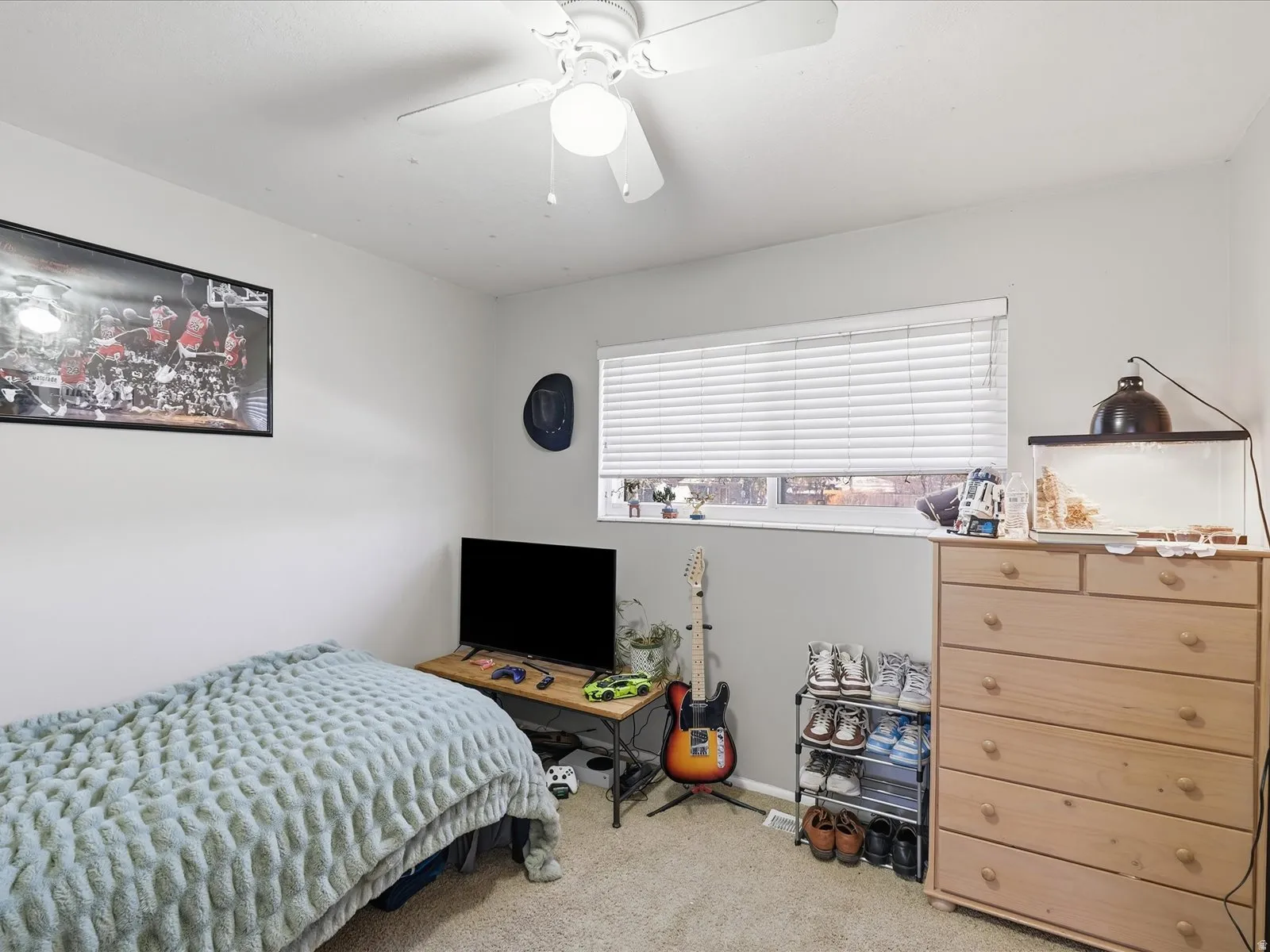 Bedroom with light colored carpet and a ceiling fan