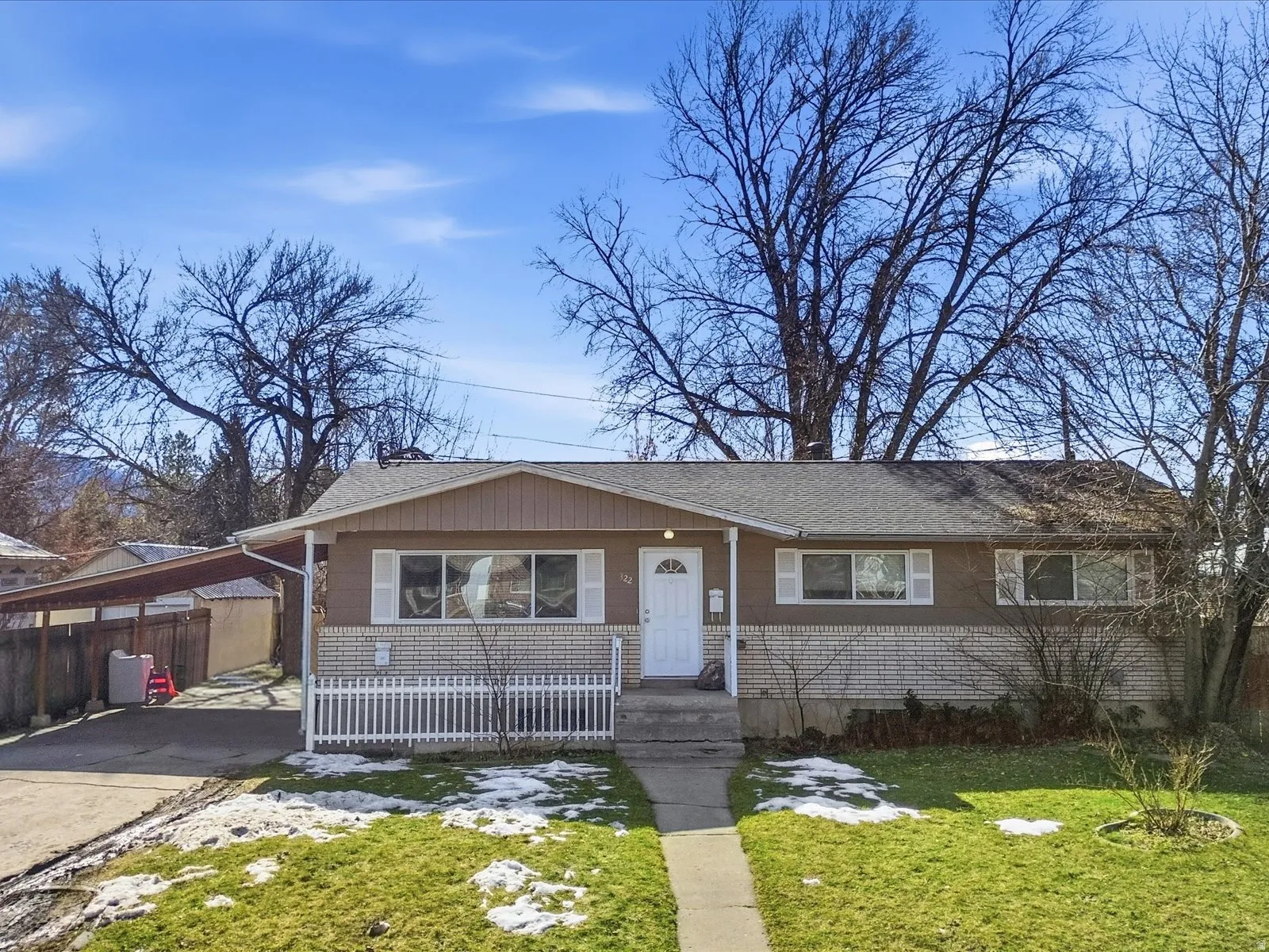 View of front of home with a shingled roof, driveway, and covered porch