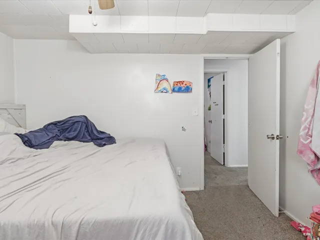 Carpeted bedroom with baseboards and a ceiling fan