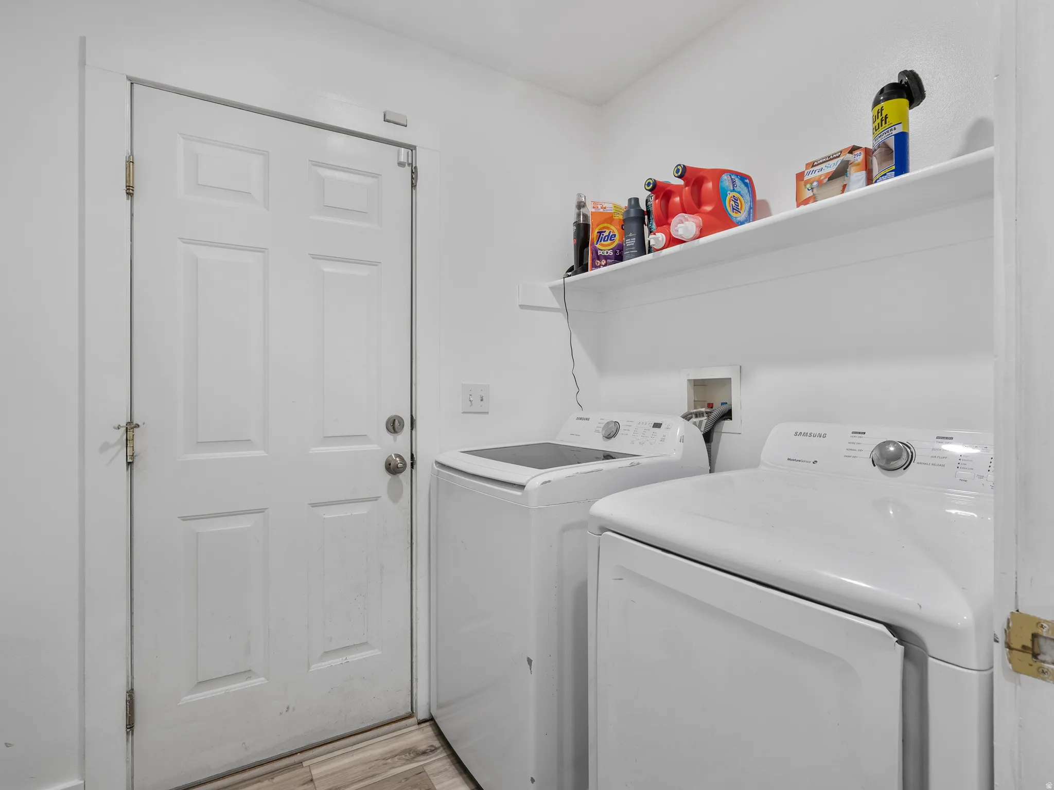 Laundry area with washing machine and clothes dryer and light wood finished floors