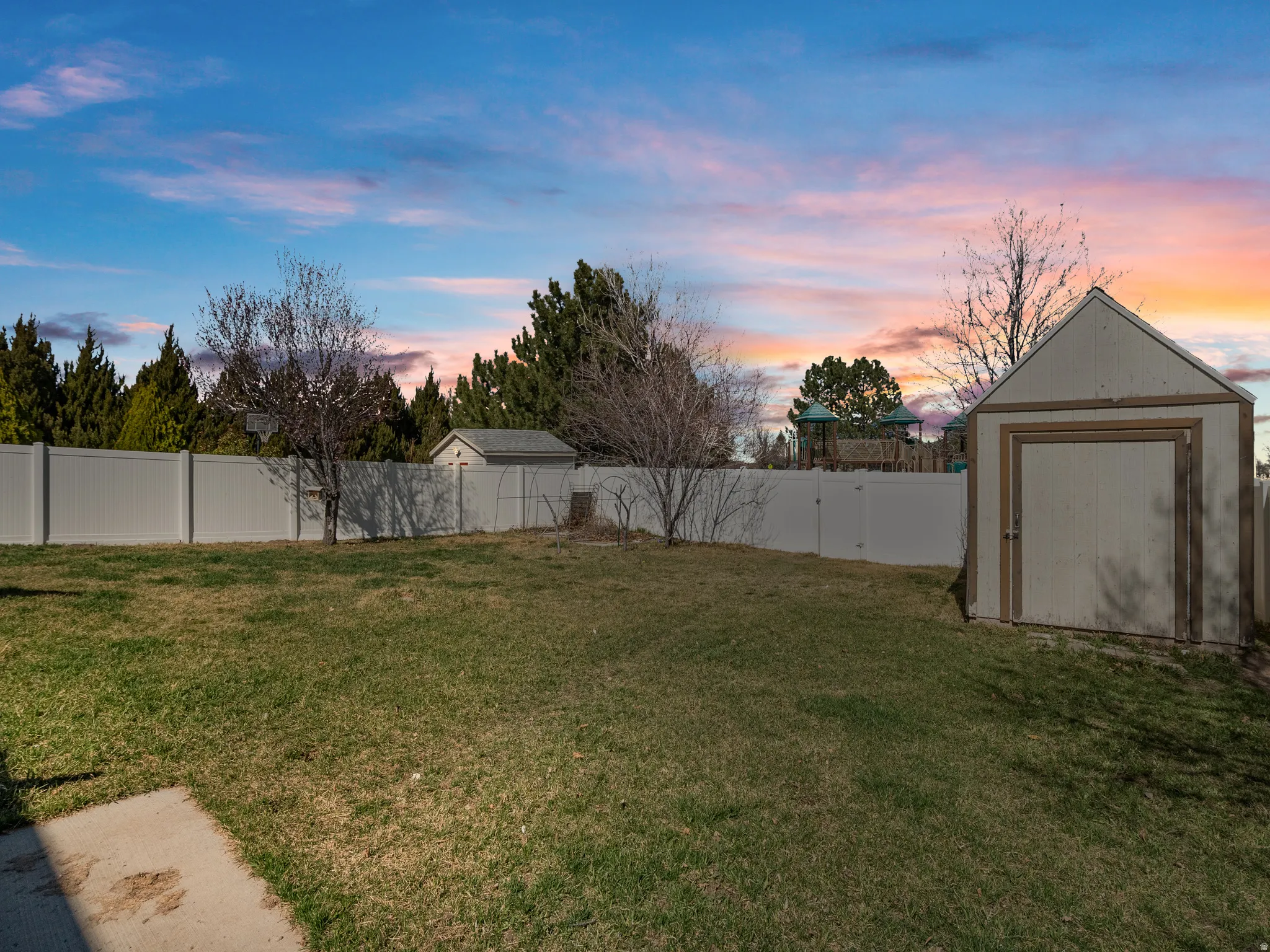 Fenced backyard featuring a shed