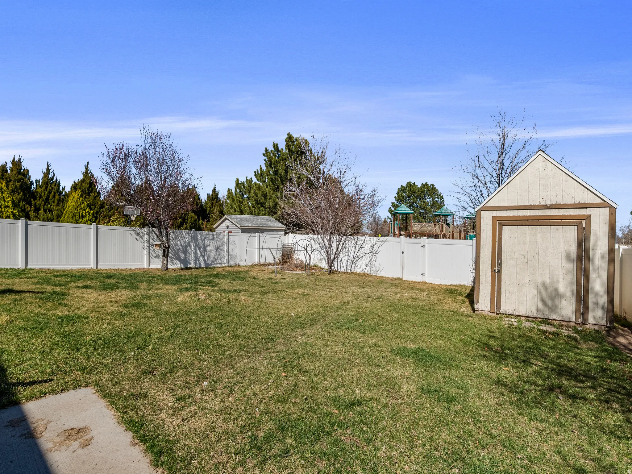 Fenced backyard featuring a shed