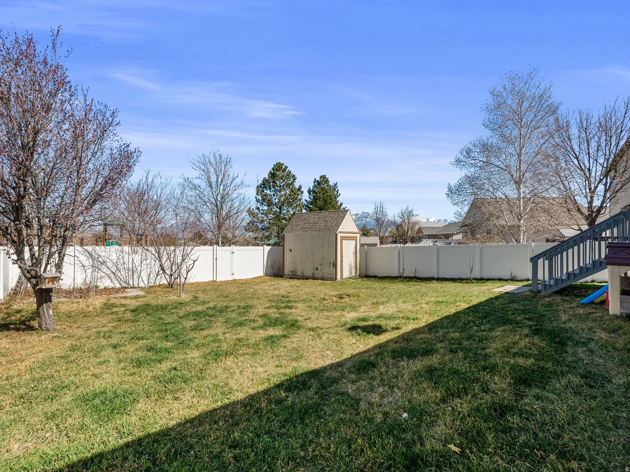 Fenced backyard with a storage shed