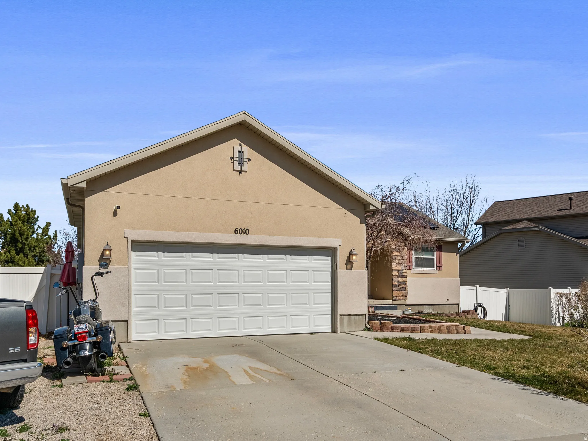 Ranch-style house with stucco siding, concrete driveway, and an attached garage