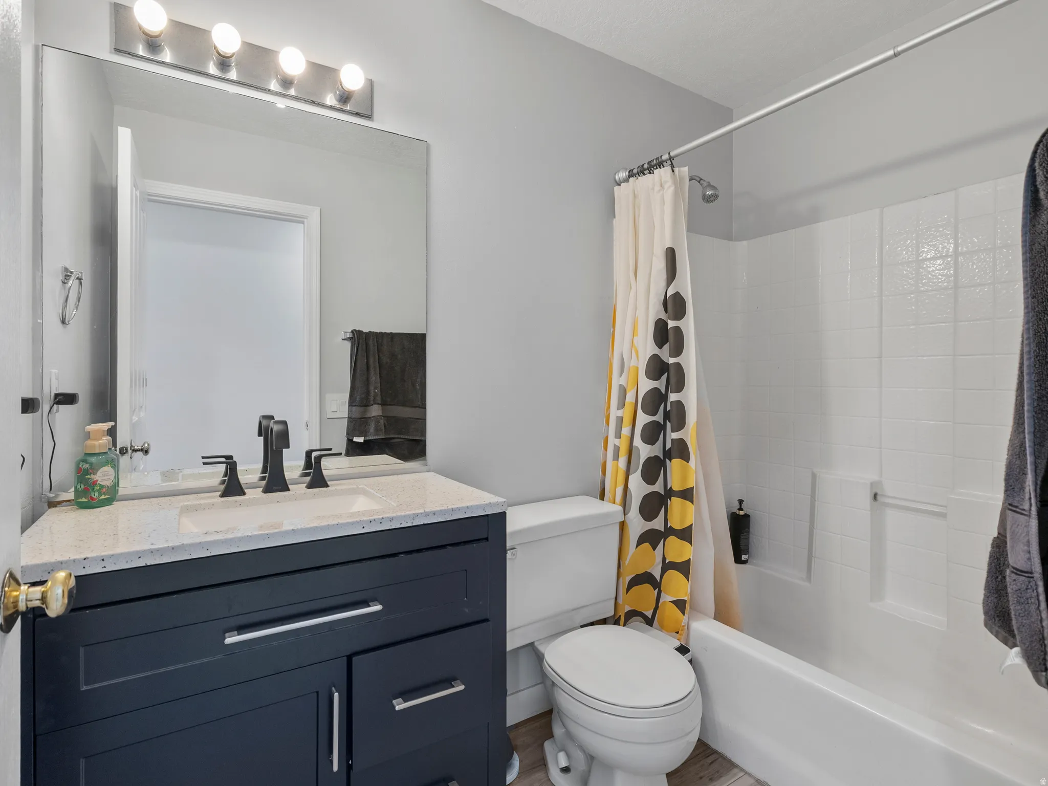 Bathroom featuring vanity and shower / bath combo with shower curtain