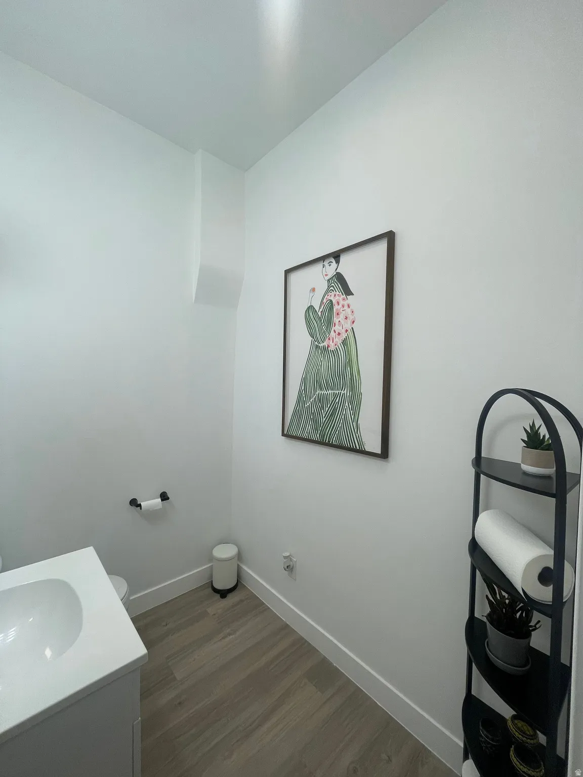 Half bathroom with vanity and dark wood-style floors